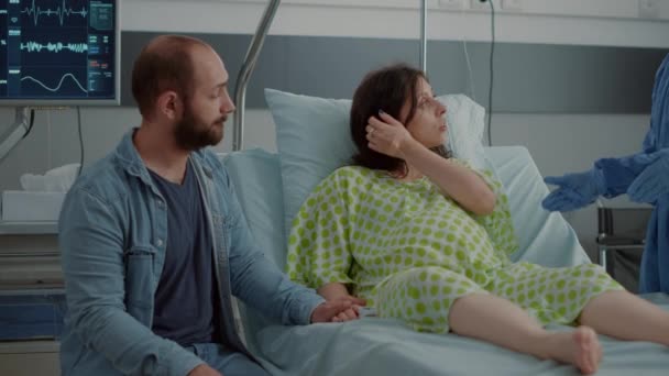Ung kvinna med babybula sittande i sjukhussäng — Stockvideo