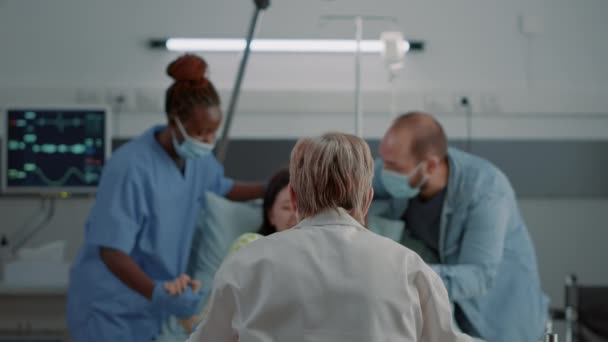 Doctor and african american nurse helping pregnant woman — Stock Video