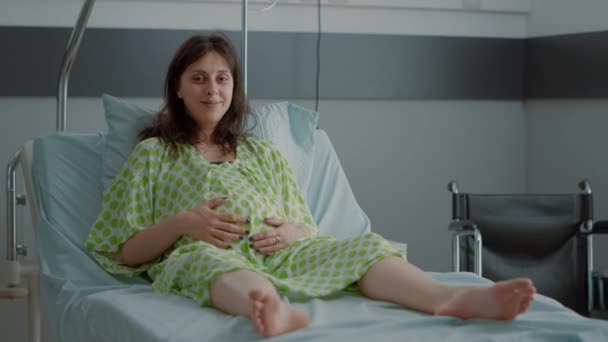 Hastane koğuşunda oturan hamile beyaz kadın portresi. — Stok video