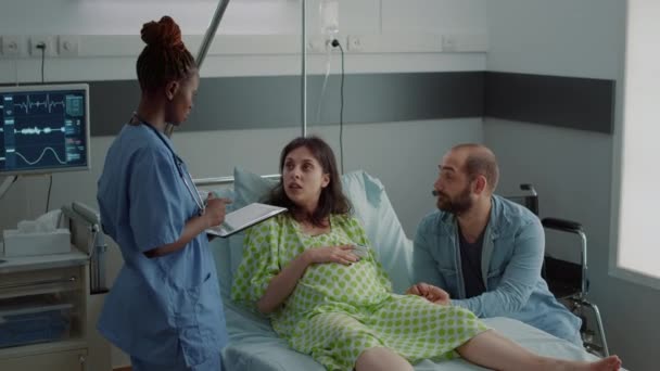 Infermiera di etnia afroamericana che parla con una paziente incinta — Video Stock