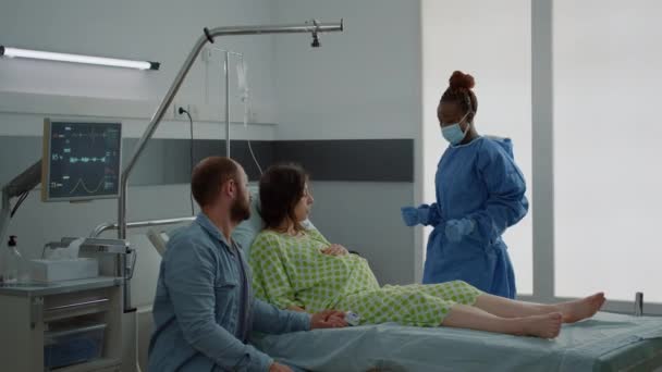 Žena čeká dítě sedící v nemocnici s manželem — Stock video