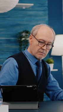 Üst düzey bir adam aynı anda dizüstü bilgisayar ve tablet kullanıyor.