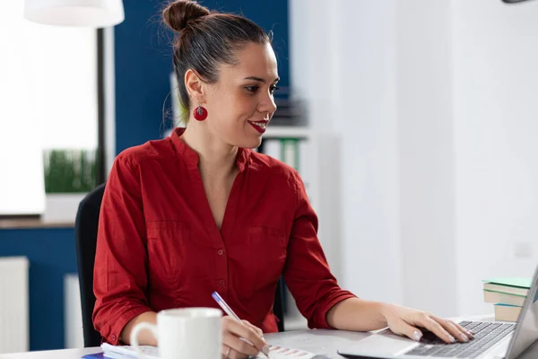 Donna d'affari sorridente che legge i dati dallo schermo del computer portatile — Foto Stock