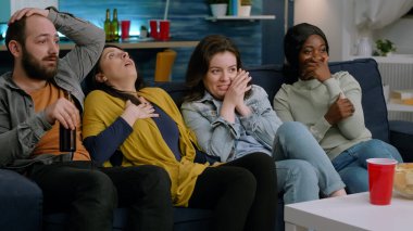 Televizyondaki korkunç filmde çok ırklı bir grup izliyor.