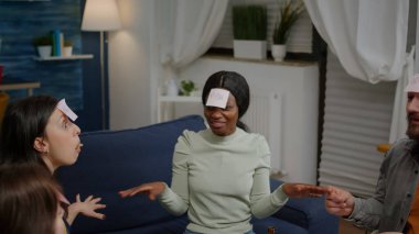 Alnına yapışkan notlar iliştirilmiş karışık ırk arkadaşları tahmin et kim oynuyor.