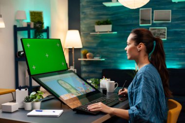 Kadın fotoğrafçı stüdyoda rötuş yapıyor.