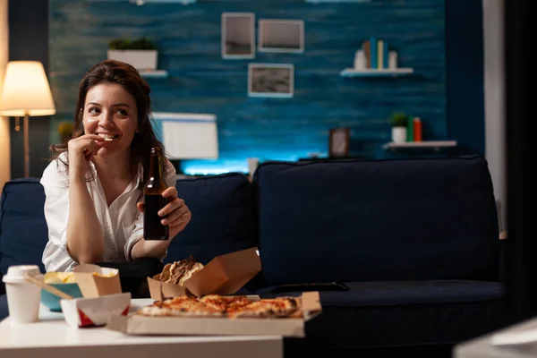 Glückliche Frau, die abends auf dem Sofa sitzt und sich Comedy-Film im Fernsehen ansieht — Stockfoto