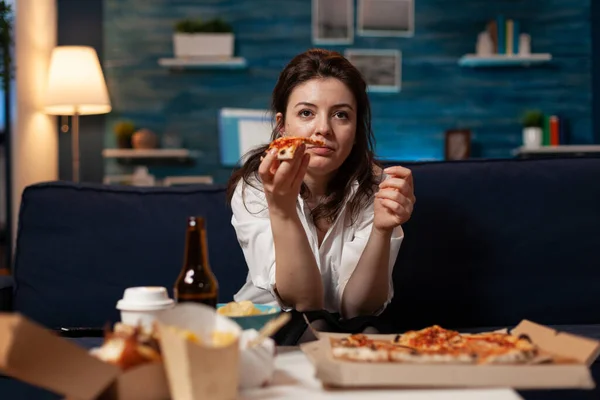 Retrato de la mujer viendo la película de comedia comiendo sabrosa rebanada de pizza entrega relajante en el sofá — Foto de Stock