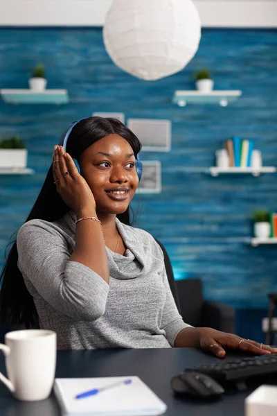 African american student wearing headphone listening online learning course — Stockfoto