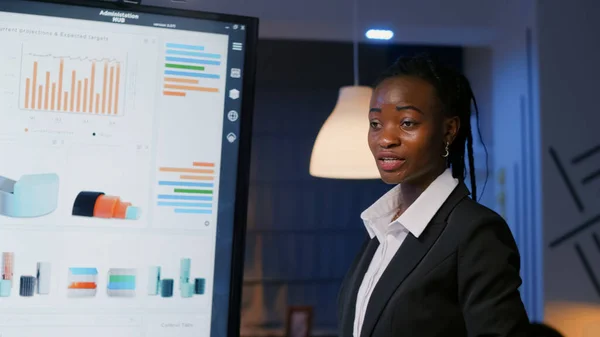 Africký výkonný manažer stojí před prezentačním monitorem — Stock fotografie