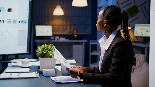 Focalizzato workaholic afro-americano donna d'affari che lavora in azienda grafici finanziari presentazione — Foto Stock