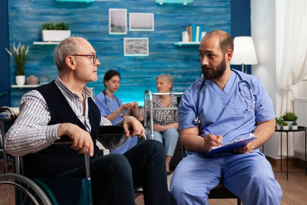 Support assistant man worker writing medication treatment on clipboard