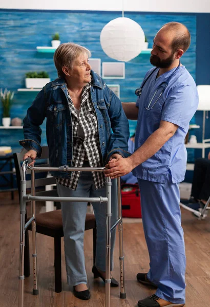 Social asisstant man worker helping pensioner disabled senior woman — Stock Photo, Image