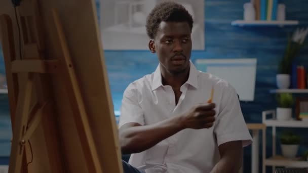 Fekete fiatal művész ceruzával és eszközökkel mestermű — Stock videók