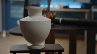Evdeki sanat atölyesindeki beyaz vazoyu kapat.