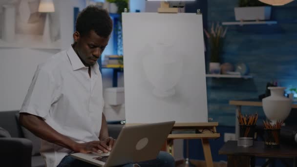 Artista creativo negro sosteniendo ordenador portátil en estudio de arte — Vídeo de stock