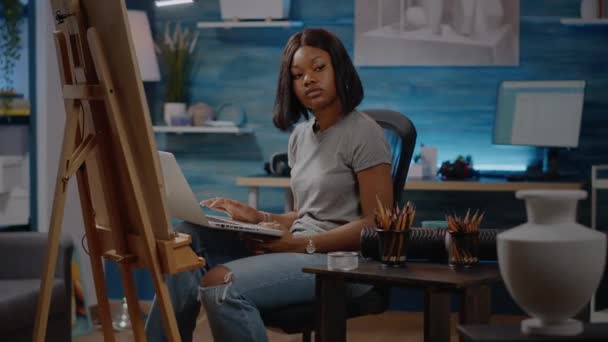 Afrykański amerykański artysta piszący na laptopie w studio — Wideo stockowe