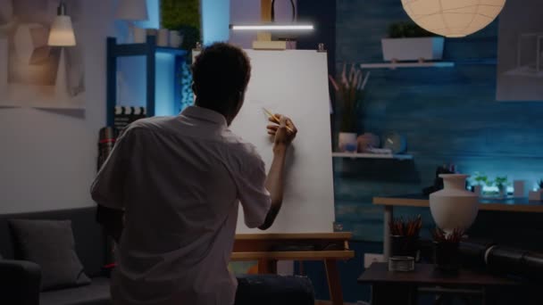 Artist of african american ethnicity using vase for drawing inspiration — Stockvideo