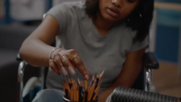 Nahaufnahme eines schwarzen behinderten Künstlers und Bleistifte auf dem Tisch — Stockvideo