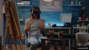 VR gözlüklü Afrikalı Amerikalı sanatçı teknoloji kullanarak resim çiziyor.