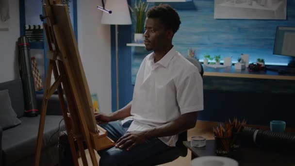 African american artist sitting in drawing studio — Stock Video