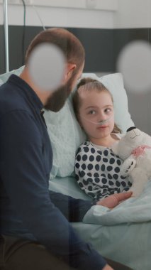 Babası hasta kızını tutarak tıbbi hastalıklara karşı ilaç tedavisini açıklıyor.