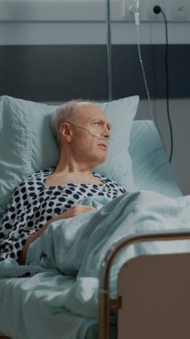 Afro-Amerikalı doktor hastane koğuşunda hasta bir hastayla konuşuyor.