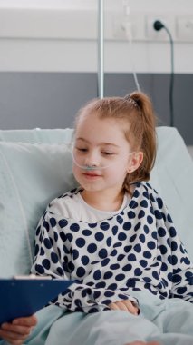 Hastanelik olan küçük hasta kız, ameliyattan sonra yatakta yatıyor.