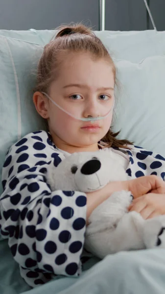 Портрет маленької дівчинки-пацієнта в кисневій носовій трубці, що спить у відновленні ліжка — стокове фото