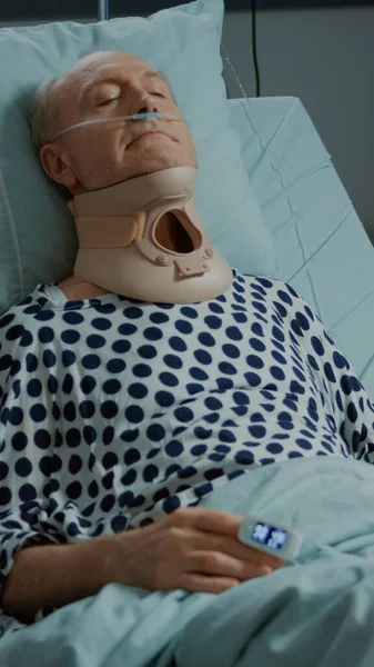 Paciente idoso sentado no leito da enfermaria hospitalar com colar cervical — Fotografia de Stock