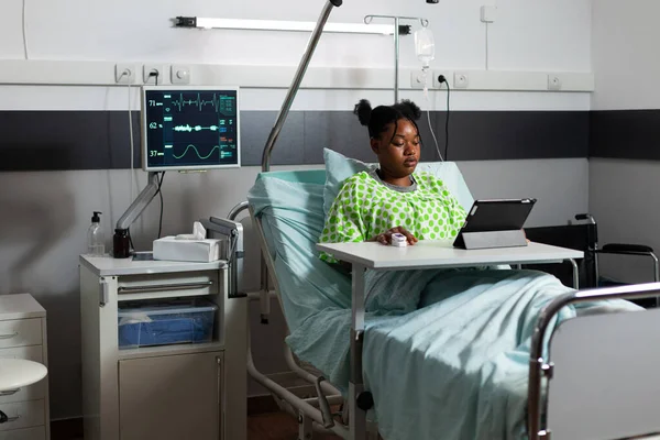 Afro-Amerikaanse patiënt zit in ziekenhuis afdeling bed — Stockfoto