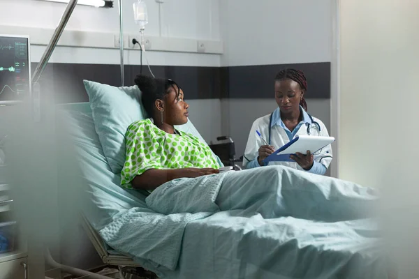 Afro-américain jeune adulte avec la maladie parler au médecin — Photo