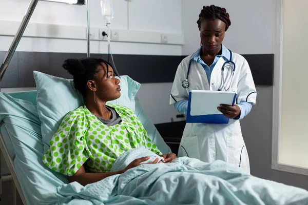 Professional doctor talking to afro patient