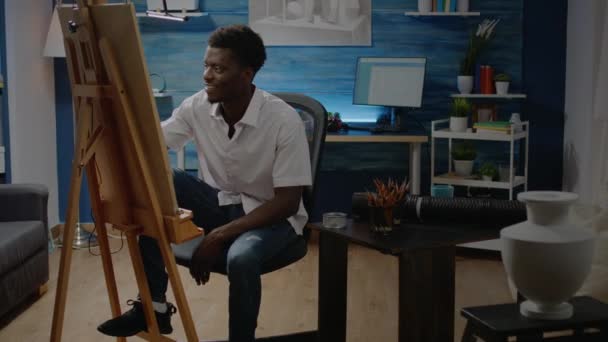 Afrykański amerykański dorosły siedzi w pracowni rysunku — Wideo stockowe