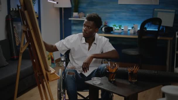 Jovem artista negro com deficiência usando ferramentas para desenho moderno — Vídeo de Stock