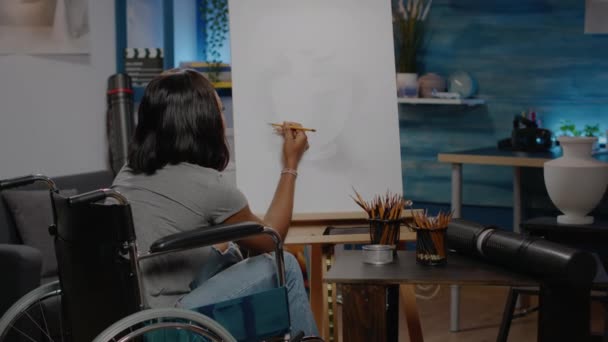 Zwarte invalide kunstenaar met een handicap met potlood op doek — Stockvideo