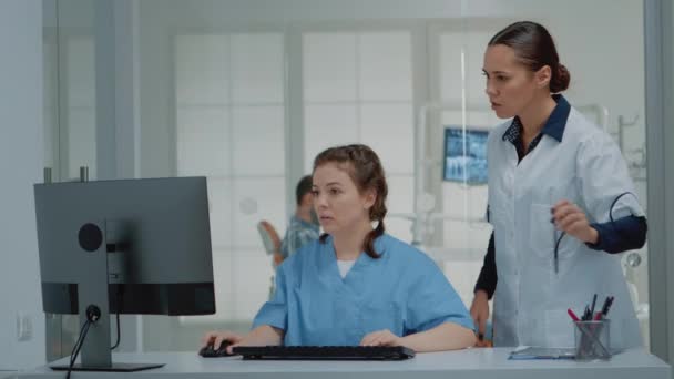 Zespół stomatologiczny specjalistów patrzących na ekran komputera — Wideo stockowe