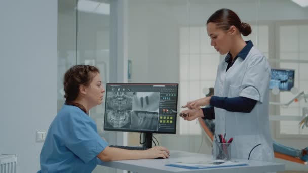 Tandarts houden tandheelkundige x ray scan in vergelijking met radiografie — Stockvideo