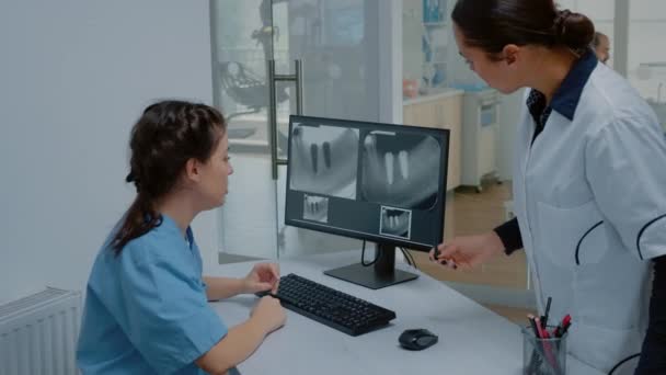 Estomatólogo y enfermero examinando escáner dental de rayos X — Vídeo de stock