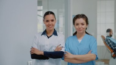 Diş hekimliği kliniğinde duran sağlık görevlisi ve hemşire.