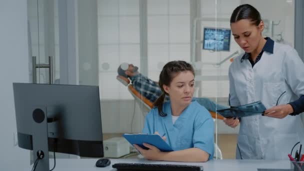 Professioneel team van tandarts en verpleegkundige die werken aan patiëntentandverzorging — Stockvideo