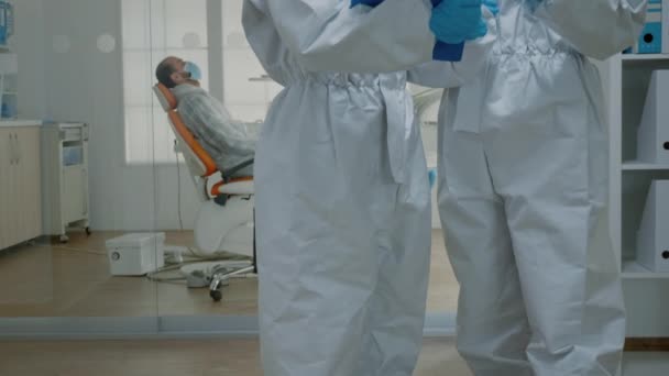 Estomatólogos profesionales que usan trajes ppe en la clínica oral — Vídeo de stock