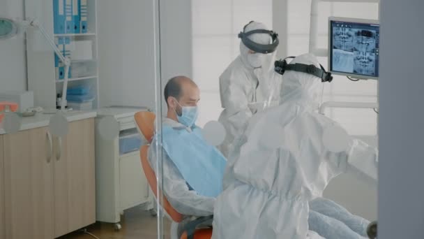 Lo staff di odontoiatria indossa tute protettive che fanno consulenza per la cura dei denti — Video Stock