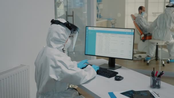 Stomatologi sjuksköterska sitter vid skrivbordet med hjälp av modern dator — Stockvideo