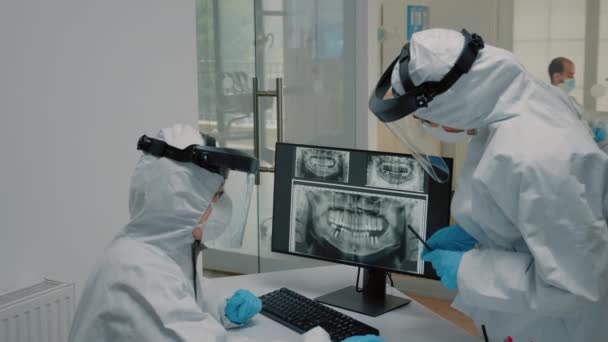 Personal de odontología que mira el escáner dental de rayos X con trajes ppe — Vídeos de Stock