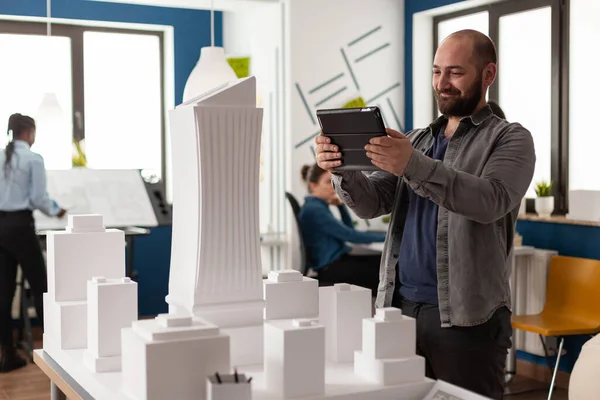Arbeitsmanager schaut im Architekturbüro auf Tablet — Stockfoto