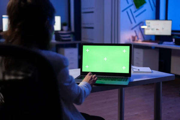 Achteraanzicht van zakenvrouw op zoek naar groene scherm laptop — Stockfoto
