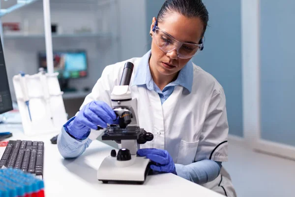 Médico microbiólogo mujer analizando los resultados de la vacuna con microscopio médico —  Fotos de Stock