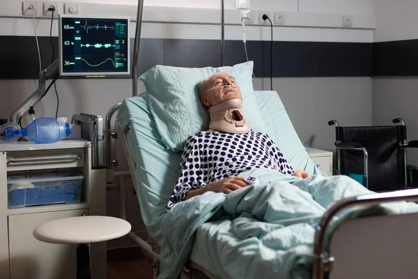 Älterer Mann liegt mit Cerivalkragen im Krankenhausbett — Stockfoto