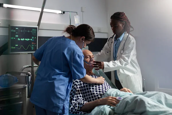 Afrikanischer Arzt hilft Seniorin mit Beatmungsschlauch beim Atmen — Stockfoto